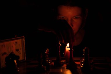 Mum ışığında satranç oynayan, satranç oynayan bir kız.