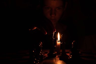 Mum ışığında satranç oynayan, satranç oynayan bir kız.