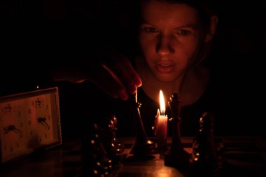 Mum ışığında satranç oynayan, satranç oynayan bir kız.