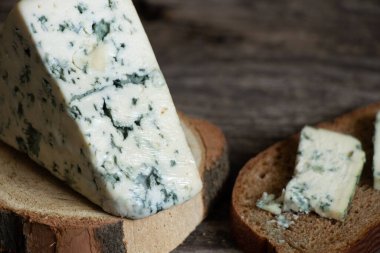 Ahşap bir masanın üzerinde bir parça mavi peynir.