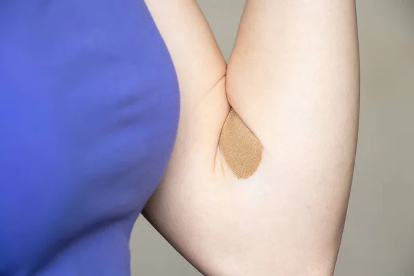 a plaster on the arm after taking blood from a vein, taking tests