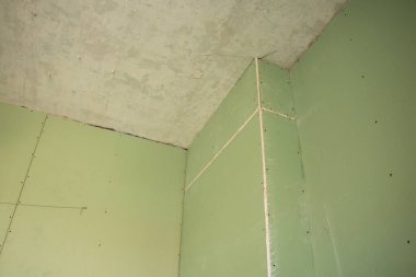 the wall is sheathed with moisture-resistant green plasterboard in the apartment, renovation work at home