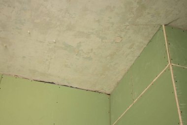 the wall is sheathed with moisture-resistant green plasterboard in the apartment, renovation work at home