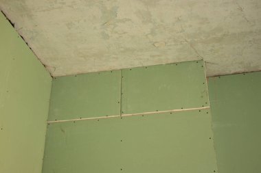 the wall is sheathed with moisture-resistant green plasterboard in the apartment, renovation work at home