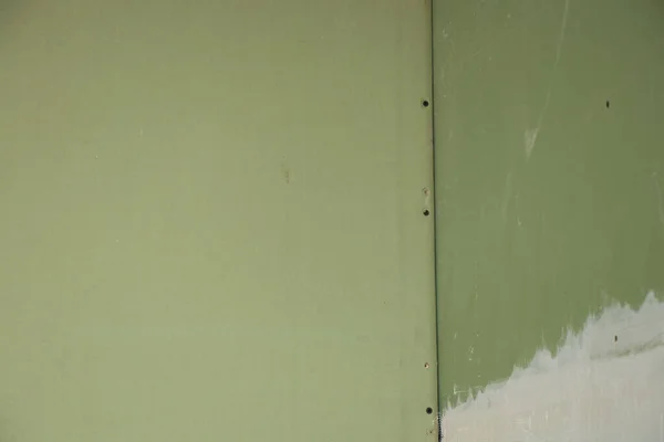 the wall is sheathed with moisture-resistant green plasterboard in the apartment, renovation work at home