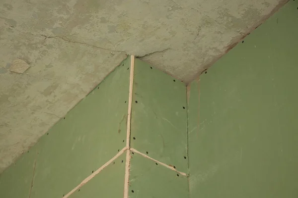 the wall is sheathed with moisture-resistant green plasterboard in the apartment, renovation work at home