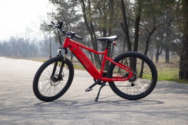 Ukraine Dnipro 05.04.2021 - a new red electric bike stands in a park in nature, new technologies