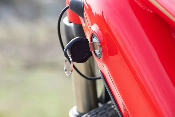 the key is inserted into the keyhole on the frame of the e-bike outdoors in the sun