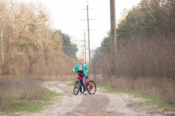 girl rides an electric bike in the spring forest in Ukraine in the city of Dnipro, outdoor recreation