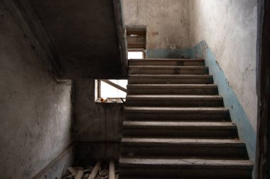 Merdiveni ve terk edilmiş evi olan terk edilmiş eski bir bina.