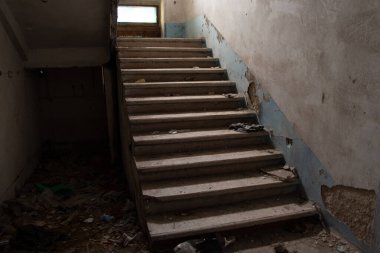 Merdiveni ve terk edilmiş evi olan terk edilmiş eski bir bina.