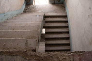 Merdiveni ve terk edilmiş evi olan terk edilmiş eski bir bina.