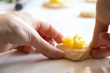 Evde patatesli turta yapma süreci mutfakta beyaz bir masada, ev yapımı patates alışkanlığı.