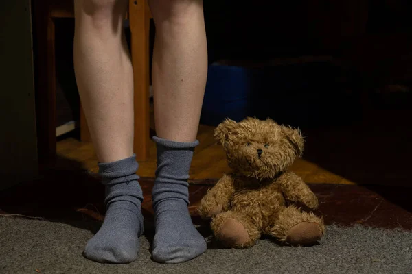 Piedi Femminili Calzini Orsacchiotto Marrone Sul Pavimento Una Stanza Buia — Foto Stock