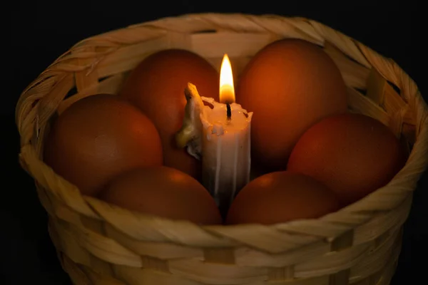 在昏暗的东方假日里 黄色的鸡蛋和蜡烛在柳条筐里燃着蜡烛 — 图库照片