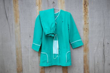 Ukrayna 'nın sokaklarında asılı duran bir askıda asılı eski bir tıbbi takım elbise, hemşire üniforması.