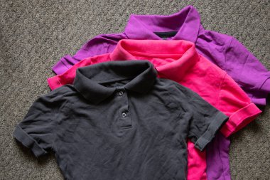 Polo çok renkli buruşuk bir yalan. Masanın üzerinde. Yakından, kadın polosu.