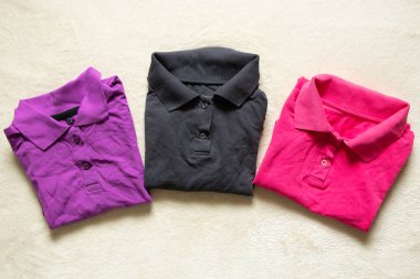 Polo çok renkli buruşuk bir yalan. Masanın üzerinde. Yakından, kadın polosu.