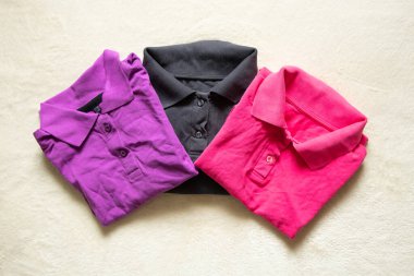 Polo çok renkli buruşuk bir yalan. Masanın üzerinde. Yakından, kadın polosu.