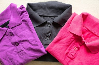 Polo çok renkli buruşuk bir yalan. Masanın üzerinde. Yakından, kadın polosu.