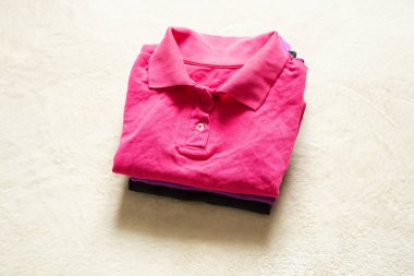 Polo çok renkli buruşuk bir yalan. Masanın üzerinde. Yakından, kadın polosu.