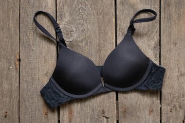 Siyah sütyen eski ahşap bir masanın üzerinde duruyor.