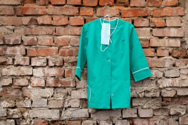 Ukrayna 'nın sokaklarında asılı duran bir askıda asılı eski bir tıbbi takım elbise, hemşire üniforması.