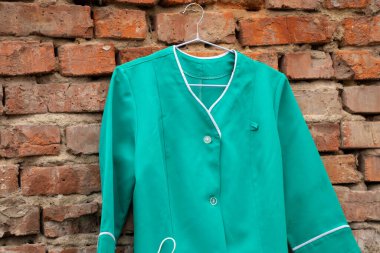 Ukrayna 'nın sokaklarında asılı duran bir askıda asılı eski bir tıbbi takım elbise, hemşire üniforması.