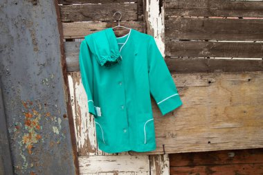 Ukrayna 'nın sokaklarında asılı duran bir askıda asılı eski bir tıbbi takım elbise, hemşire üniforması.