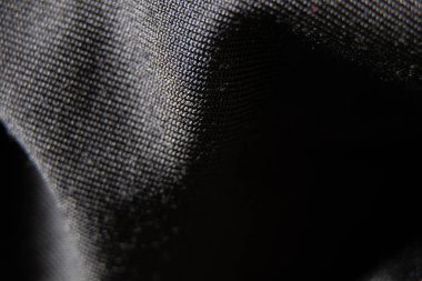 Siyah kumaş arka planda yakın plan olarak buruşur