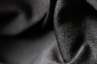 Siyah kumaş arka planda yakın plan olarak buruşur