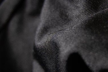 Siyah kumaş arka planda yakın plan olarak buruşur