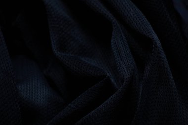 Koyu mavi kumaş arka planda yakın plan olarak buruşmuş