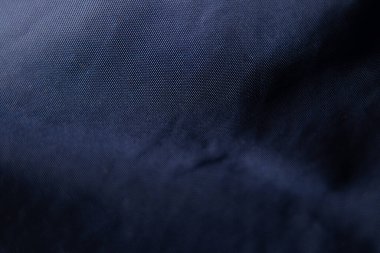 Koyu mavi kumaş arka planda yakın plan olarak buruşmuş