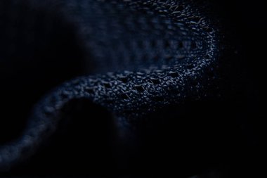 Koyu mavi kumaş arka planda yakın plan olarak buruşmuş