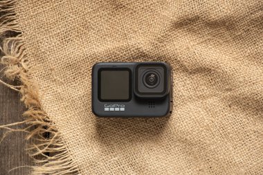 Ukrayna Dnipro 18.04.2021 - GoPro HERO 9 çuval bezi ve yeni teknolojiler üzerine kurulu ahşap bir masada yatıyor