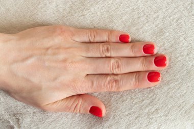 Kırmızı manikürlü kadın elleri izole edilmiş arka planda.