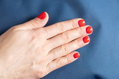 Kırmızı manikürlü kadın elleri izole edilmiş arka planda.