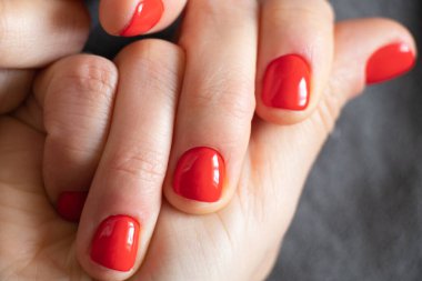 Kırmızı manikürlü kadın elleri izole edilmiş arka planda.