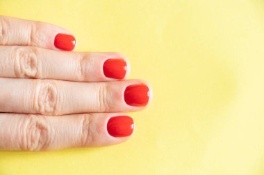 Kırmızı manikürlü kadın elleri izole edilmiş arka planda.