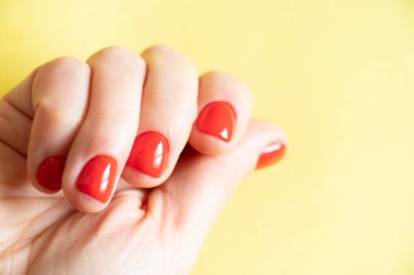 Kırmızı manikürlü kadın elleri izole edilmiş arka planda.