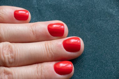 Kırmızı manikürlü kadın elleri izole edilmiş arka planda.