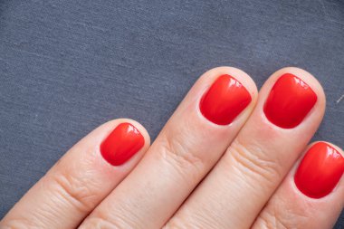 Kırmızı manikürlü kadın elleri izole edilmiş arka planda.