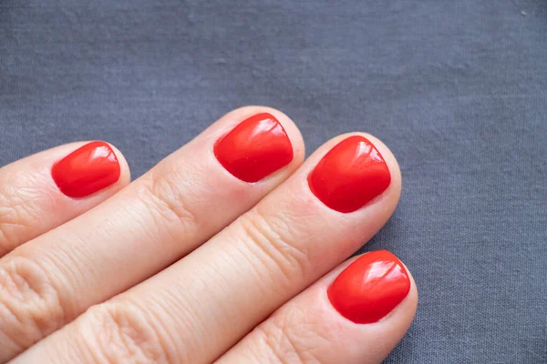 Kırmızı manikürlü kadın elleri izole edilmiş arka planda.