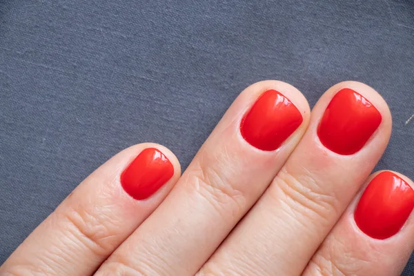 Kırmızı manikürlü kadın elleri izole edilmiş arka planda.