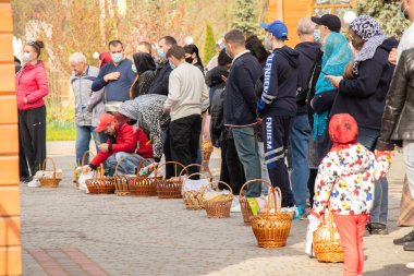 Ukrayna Dnipro, Dnipropetrovsk 02.05.2021 - Rahip Paskalya sepetlerini yiyecekle kutsadı. Tapınaktaki Hristiyanlar. Paskalyayı Ukrayna ve Paskalya 'da kutlama gelenekleri
