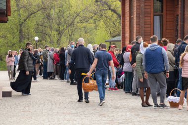 Ukrayna Dnipro, Dnipropetrovsk 02.05.2021 - Rahip Paskalya sepetlerini yiyecekle kutsadı. Tapınaktaki Hristiyanlar. Paskalyayı Ukrayna ve Paskalya 'da kutlama gelenekleri