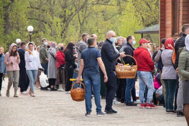 Ukrayna Dnipro, Dnipropetrovsk 02.05.2021 - Rahip Paskalya sepetlerini yiyecekle kutsadı. Tapınaktaki Hristiyanlar. Paskalyayı Ukrayna ve Paskalya 'da kutlama gelenekleri