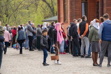 Ukrayna Dnipro, Dnipropetrovsk 02.05.2021 - Rahip Paskalya sepetlerini yiyecekle kutsadı. Tapınaktaki Hristiyanlar. Paskalyayı Ukrayna ve Paskalya 'da kutlama gelenekleri
