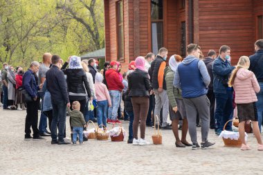 Ukrayna Dnipro, Dnipropetrovsk 02.05.2021 - Rahip Paskalya sepetlerini yiyecekle kutsadı. Tapınaktaki Hristiyanlar. Paskalyayı Ukrayna ve Paskalya 'da kutlama gelenekleri